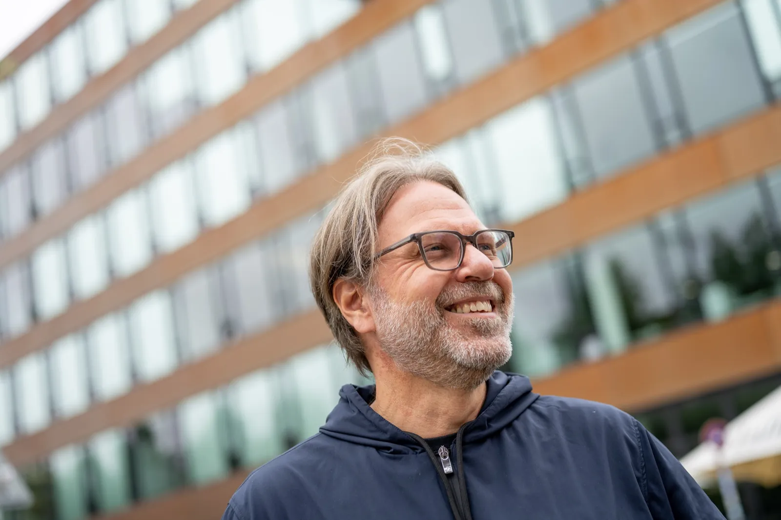 Ralf Lanwehr lachend vor einem Bürogebäude